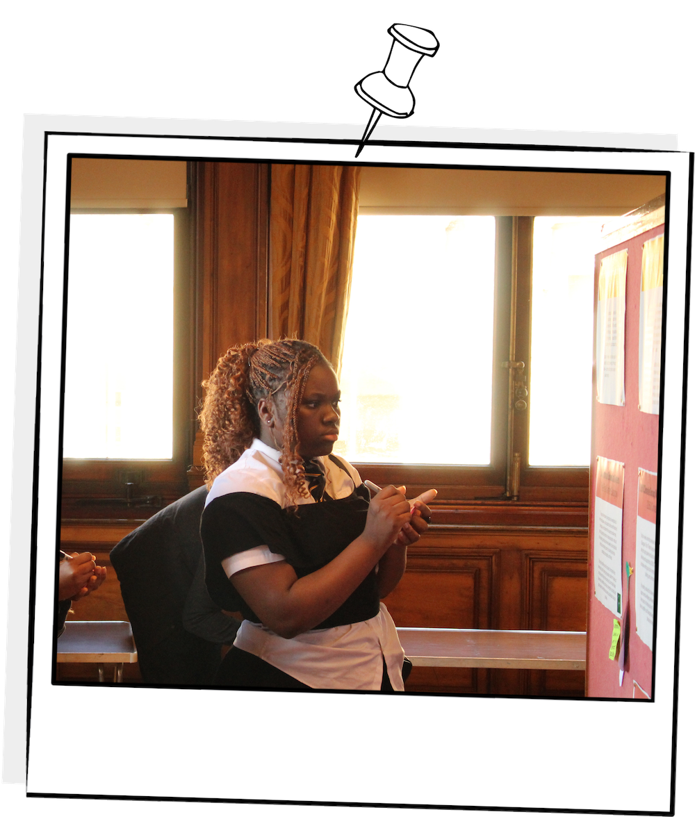 Polaroid photograph from the Youth Climate Action Fund kick-off event showing a participant writing her thoughts on the different projects featured in the 2025 Youth Climate Action Fund.